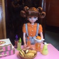 Adorable doll is making orange juice.